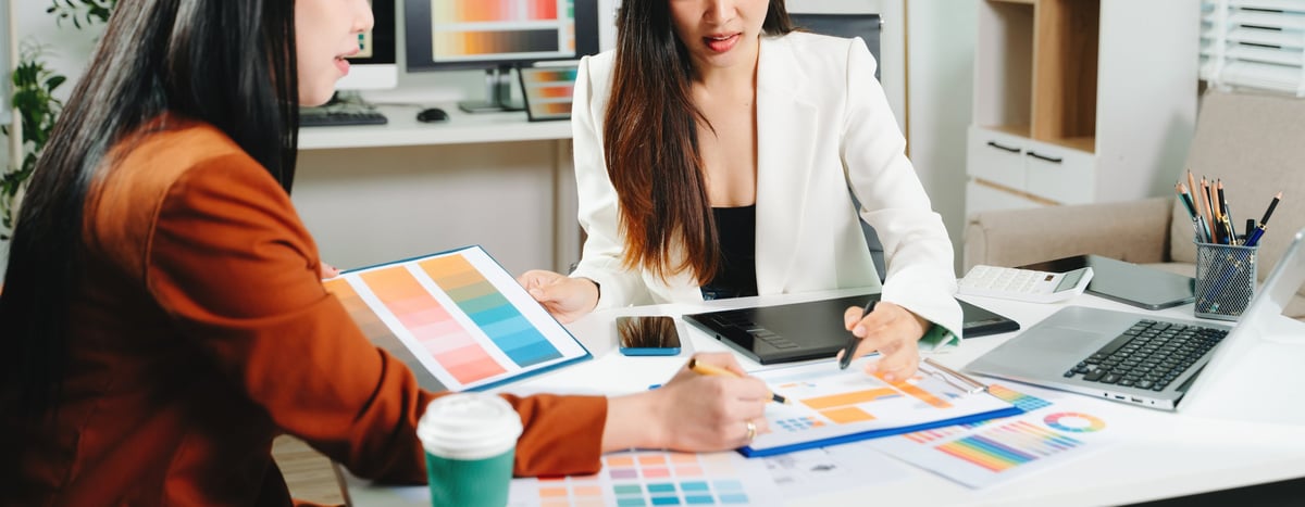 Two designers collaborating on a color palette and UX project in a modern creative office